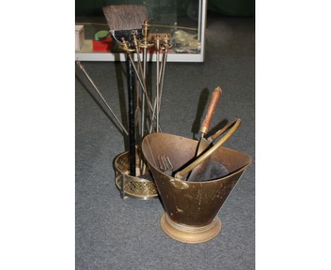 A brass coal scuttle with shovel, fire irons and tools, on circular stand