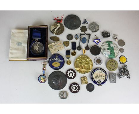 A small collection of late Victorian and later badges, tokens and medallions including a large gilt metal medallion inscribed