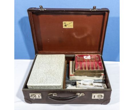 A small vintage suitcase containing cutlery