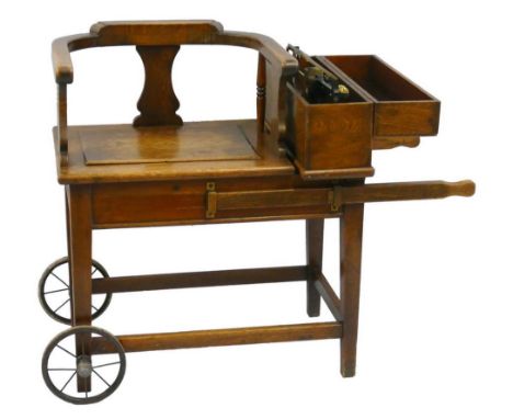 An early 20th century oak "jockeys" scales, the weighing seat with bow arms supported on spindles and splats, with the brass 