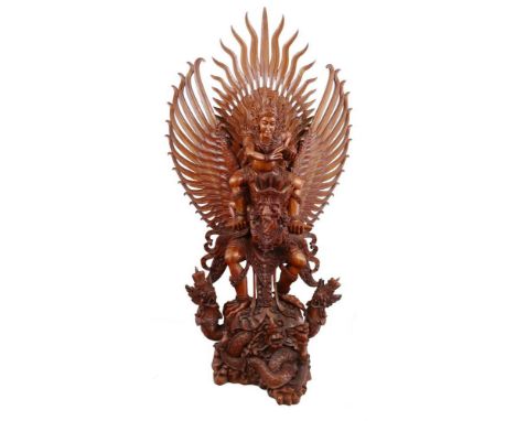 A massive Balinese carved hardwood group of Vishnu riding Garuda, 182cm high, 101cm wide, 52cm deep with mahogany wall bracke