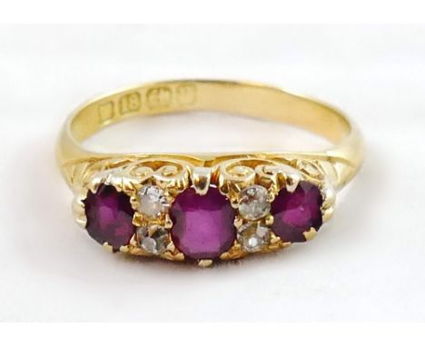 A Victorian 18ct gold ruby and diamond ring, Birmingham 1887, carved claw set with three mixed cut rubies, rose cut diamonds 