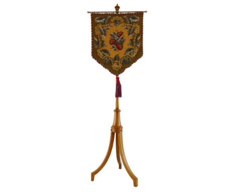A late Victorian/Edwardian satinwood pole screen, the plain stem with turned finial, rise-and-fall brass mounted shield shape