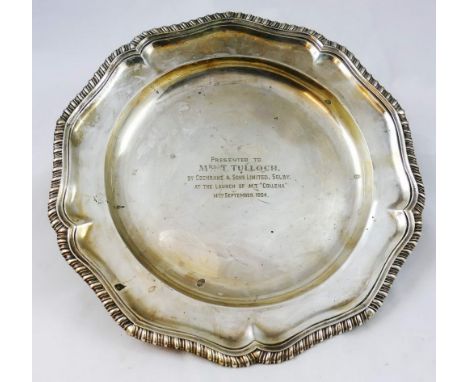 A George III silver presentation plate, makers mark poorly struck, London 1787, with a shaped gadrooned border, diameter 24.5