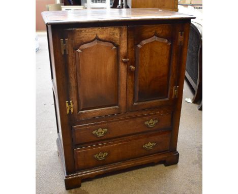 An oak TV cabinet with twin doors above two long drawers on bracket feet, height 102cm, width 81.5cm, depth 48.5cm.&nbsp;Addi
