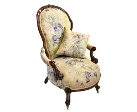 A Victorian carved walnut spoon back armchair upholstered in a later floral material on ceramic castors.Additional Informatio