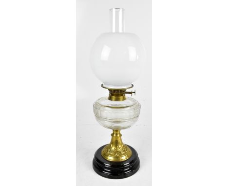 An oil lamp with opaque glass shade, clear chimney and reservoir on brass foot with relief floral detail to stepped base, hei