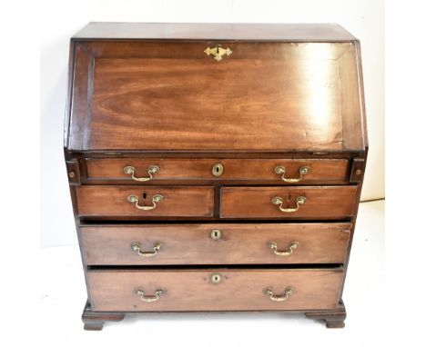 A George III mahogany bureau, the fall front enclosing a fitted interior above one long, two short and two long drawers, rais
