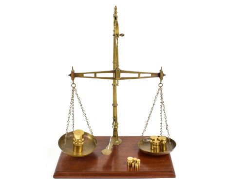 W &amp; T AVERY; a set of early 20th century balance scales, together with assorted later weights, raised on wooden plinth ba