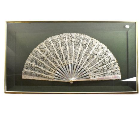 A large lace fan with embroidered floral detail and mother of pearl sticks, width 66cm, framed and glazed.