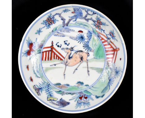 A late 18th/early 19th century Chinese doucai dish centered with a deer with bird and monkey to the border, painted six chara
