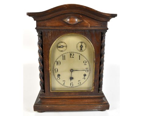 KIENZLE; a circa 1900&nbsp;German oak cased mantel clock, the silvered dial set with Arabic numerals, raised on four bun feet