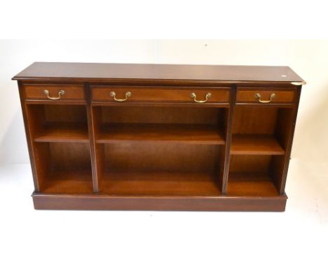 A reproduction mahogany veneered bookcase with three drawers above three adjustable shelves, height 83cm, length 150cm, depth