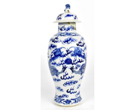 An early 20th century Chinese blue and white porcelain lidded jar, painted with four claw dragons, bearing four character Kan