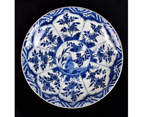 A Chinese Kangxi period porcelain charger painted in underglaze blue with floral decoration and with cafe-au-lait rim, with l