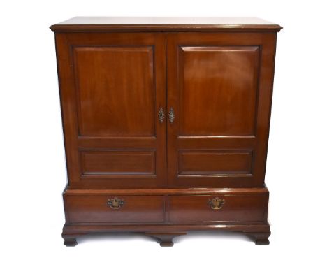 A late George III red walnut press cupboard, the moulded rectangular top above two double panelled doors enclosing three orig