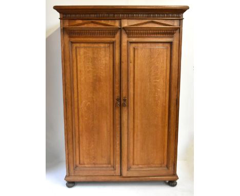 A 19th century architectural oak wardrobe with twin panelled doors enclosing hanging compartments and single base drawer, rai