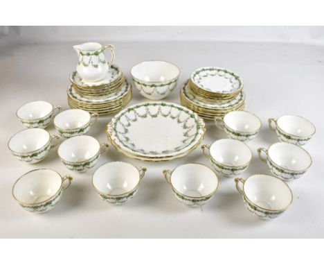 ROYAL CROWN DERBY; a green over enamelled floral transfer decorated twelve setting tea service, pattern no. 7497, with printe