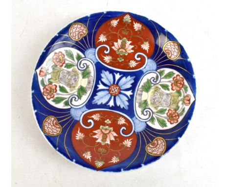 An early 20th century Japanese porcelain dish painted in enamels with Dogs of Fo and floral motifs, with double ring and six 
