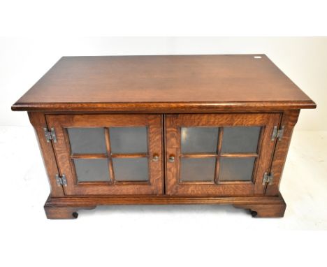 A reproduction oak television stand with twin glazed cupboard doors above bracket feet, width 80.5cm.Additional InformationMi