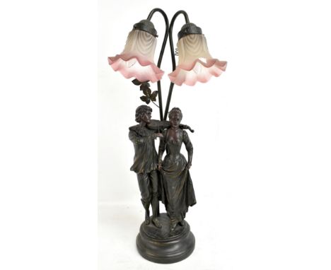 A modern decorative table lamp featuring a couple singing and playing the violin beneath two pink tinted shades, height 68cm.