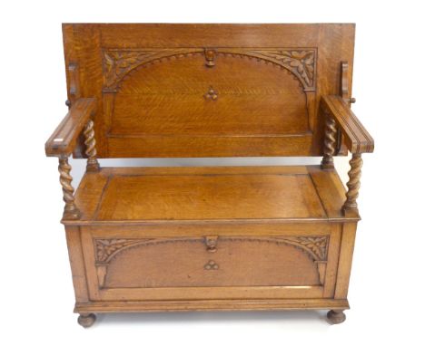 An early 20th century light oak monk's bench with barley twist columns, the hinged seat enclosing storage compartment, length