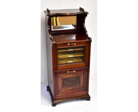 An Edwardian mahogany music cabinet with part galleried top and mirror back shelf above glazed door enclosing three shelves w