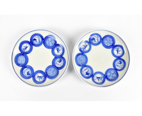A pair of Chinese blue and white shallow circular dishes each decorated with roundels, set with dwelling in landscape, stylis