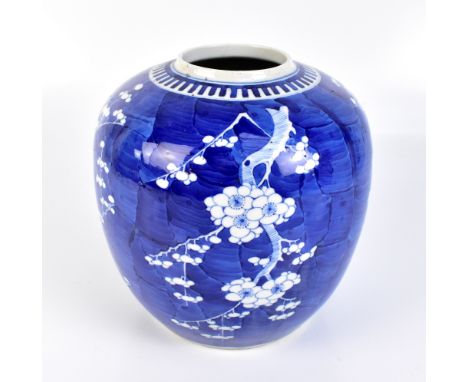 An early 20th century Chinese blue and white porcelain vase of bulbous form painted with prunus flowers on a blue ground, fou