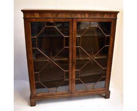 A mahogany bookcase with twin astragal glazed doors enclosing adjustable shelves, raised on bracket feet, width 122cm, height