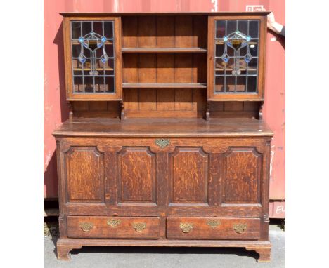 An 18th century panelled oak coffer with later 19th century applied cabinet top with lead glazed doors, the coffer with two b