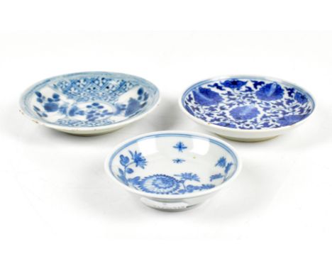 Three Chinese blue and white floral decorated saucer dishes, the larger two unmarked, the smallest with painted Jiajing Fu Gu