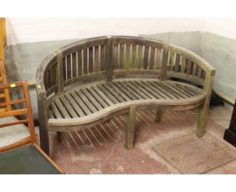 A SHAPED GARDEN HARDWOOD BENCH