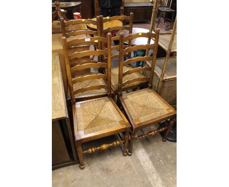 A SET OF FOUR OAK WICKER SEAT LADDER BACK DINING CHAIRS