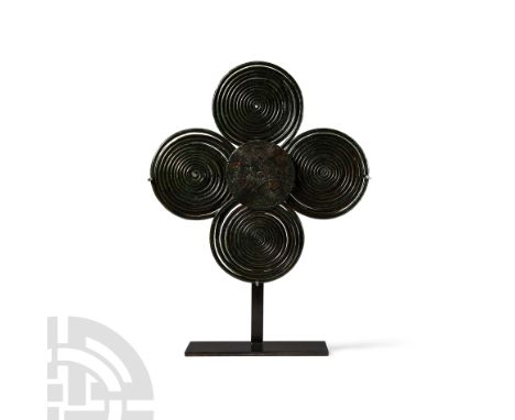 850-750 B.C. Formed as four coils of rod radiating around a central disc with pointillé decoration; substantial pin and catch