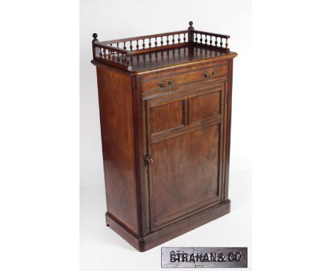 A tall Irish Victorian walnut Press, with turned gallery rail, over frieze drawer and large panel door on plinth base, stampe