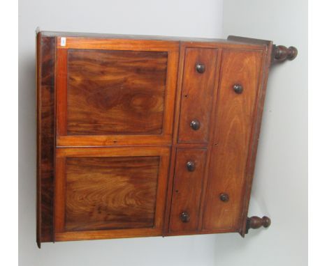 A figured mahogany Victorian Linen Press, with two panel doors over two short and two long drawers on turned feet. (1)