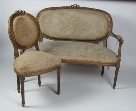A late 19th Century carved giltwood Salon Suite, consisting of a two seater couch and four matching single chairs, covered in