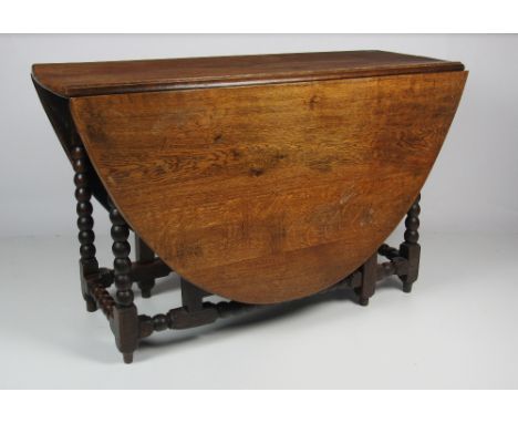 An antique heavy oak drop-leaf gate-leg Table, with bobbin turned supports, approx. 124cms (49") long. (1)Provenance :  The A