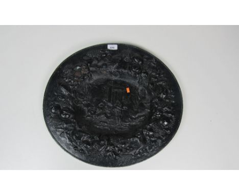 A heavy cast iron "Coalbrookdale" type oval Wall Plaque, the recessed central panel decorated with classical ruins and figure