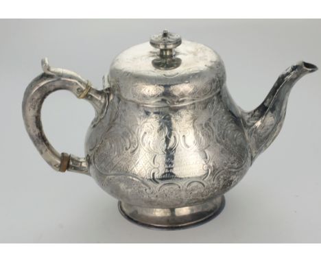 A heavy Irish silver Teapot, of lobed circular baluster form, the body profusely engraved with flowers, scrolls and other dec