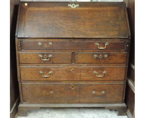 A late 18th Century figured oak drop-front Bureau, the slope top opening to reveal a fitted interior, on three long and two s