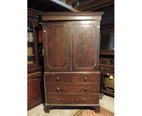 A George III period mahogany Linen Cupboard, the two figured panel doors over a base with two short and two long drawers on b