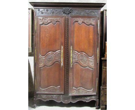 A very fine and attractive French late 18th Century carved oak Armoire, the carved and moulded cornice over frieze centred wi