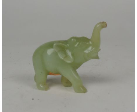 A good quality small carved jade model of an Elephant (trunk dam. slightly), on a carved wooden stand. (1)