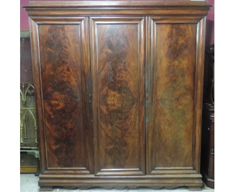 A good early Victorian figured mahogany Wardrobe, the moulded top over three large panel doors with Prince of Wales Plume, an