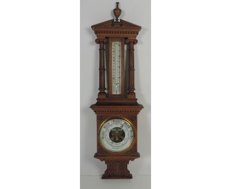 An unusual late Victorian carved oak Barometer / Thermometer, the broken pediment and dentil moulded cornice over large therm