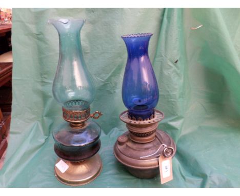 2 oil lamps, one with dark blue shade and the other with light blue shade