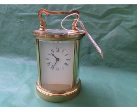 Circular cased brass carriage clock ex. Fema, enamel dial painted roman numerals