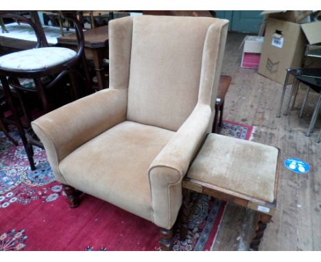 An oak framed mid-twentieth wing arm chair upholstered in light brown velour with oak and brass collared twist stem foot stal